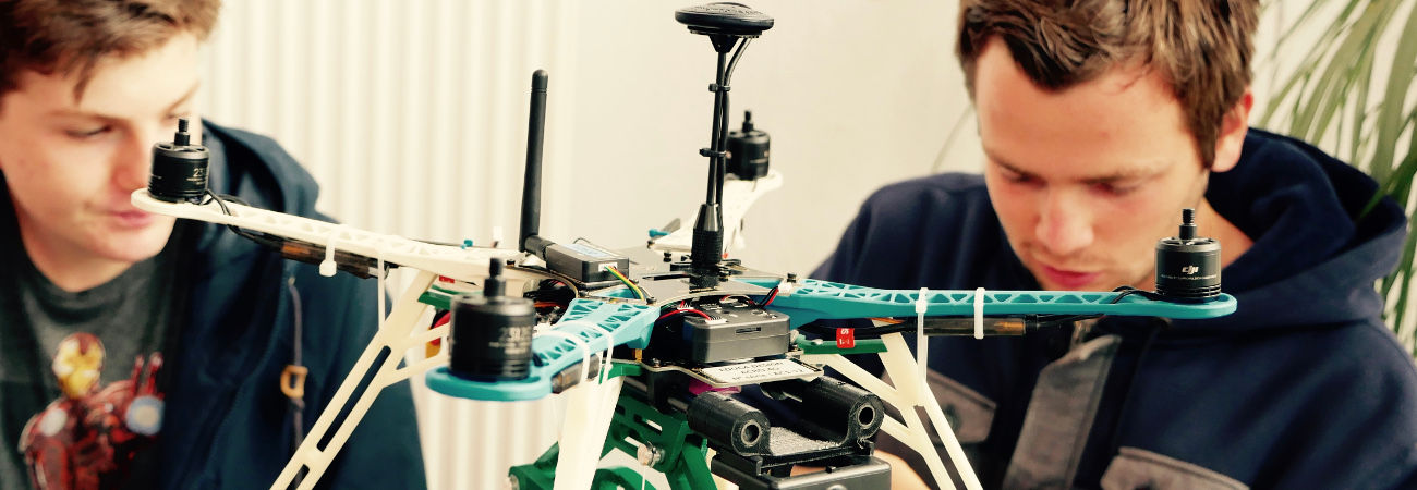 Visuel présentant des étudiants en pleine conception d'un drone aux rotors apparents