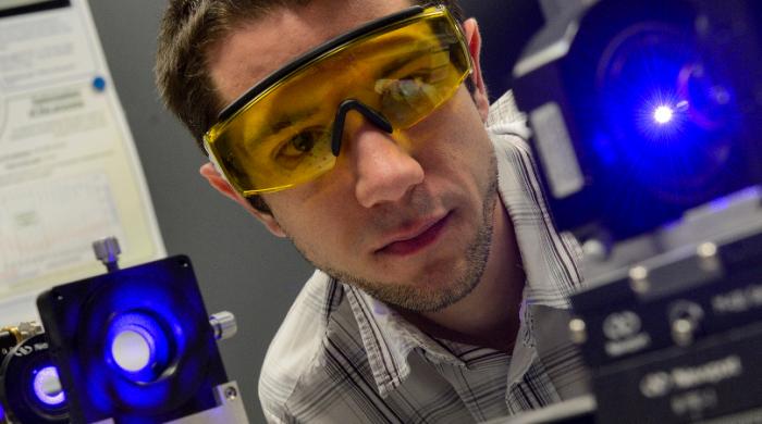 Visuel présentant un chercheur travaillant avec un laser